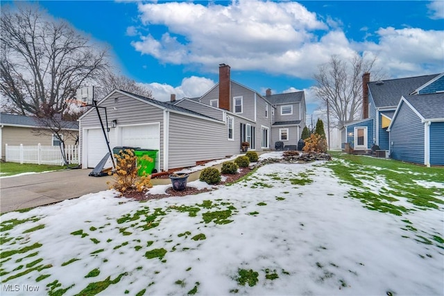 view of snow covered exterior with a garage