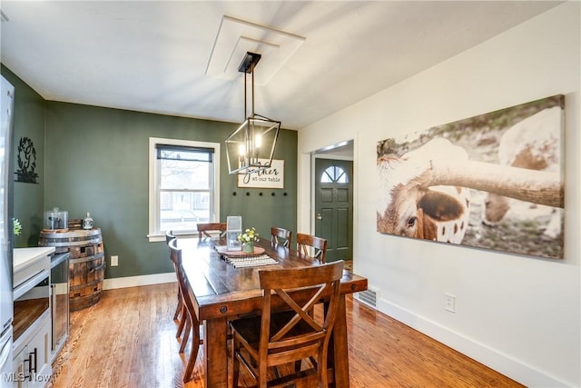 dining area featuring light hardwood / wood-style flooring and a chandelier