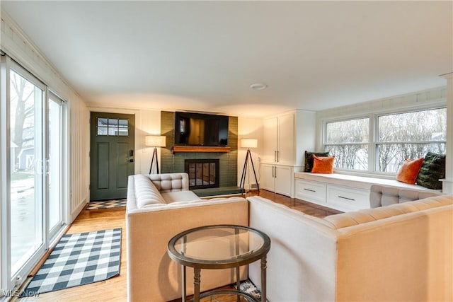 living room with a healthy amount of sunlight, a fireplace, and light hardwood / wood-style flooring