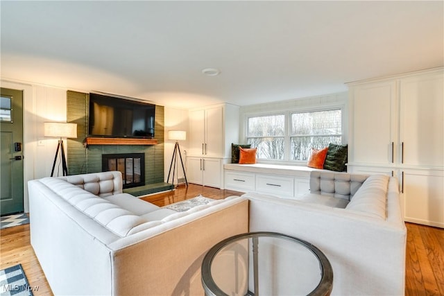 living room with a fireplace and light wood-type flooring