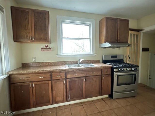 kitchen with sink, light tile patterned floors, and stainless steel gas stove