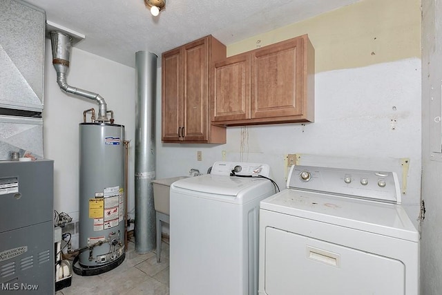 clothes washing area with cabinets, gas water heater, sink, and independent washer and dryer