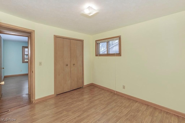 unfurnished bedroom featuring a closet and light hardwood / wood-style flooring