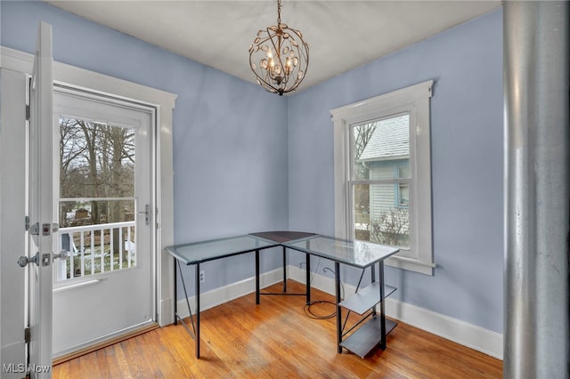 office space with a notable chandelier and light wood-type flooring