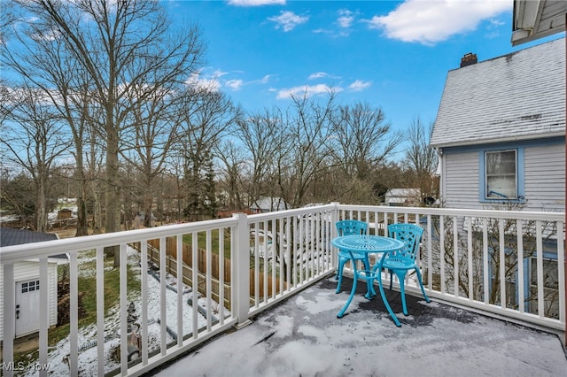 view of snow covered back of property