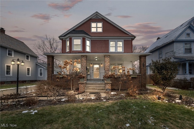 front facade with a porch and a yard