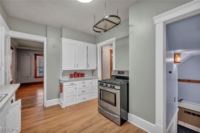 kitchen featuring white cabinetry, stainless steel range with gas cooktop, and light hardwood / wood-style floors