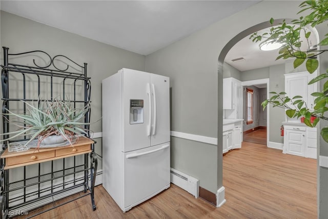 kitchen with a baseboard heating unit, light hardwood / wood-style floors, white fridge with ice dispenser, and white cabinets