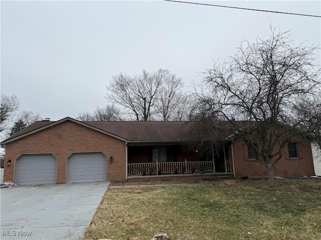 single story home featuring a garage, covered porch, and a front yard