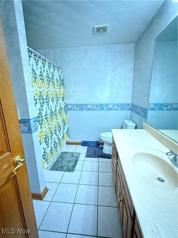 bathroom featuring vanity, toilet, and tile patterned flooring