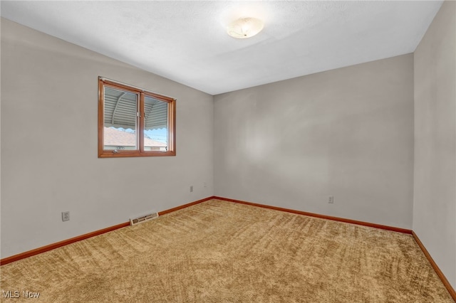 carpeted spare room with a textured ceiling