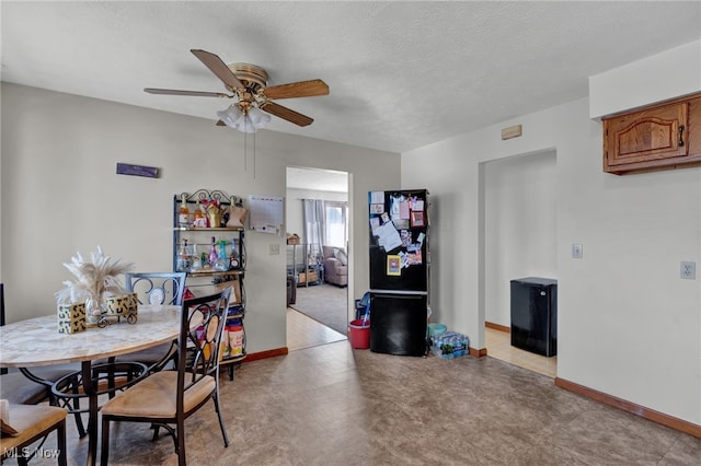 dining space featuring ceiling fan and a textured ceiling