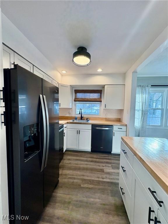 kitchen with white cabinets, dishwashing machine, and black refrigerator with ice dispenser