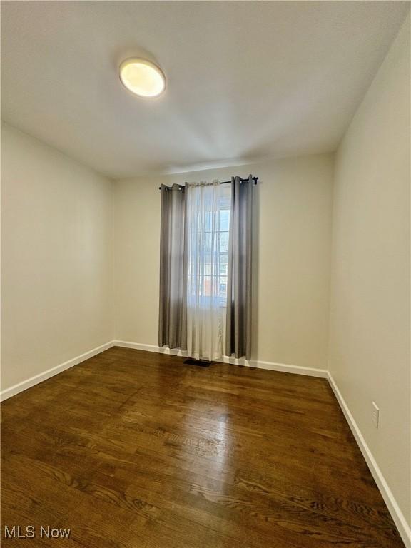 empty room with dark wood-type flooring