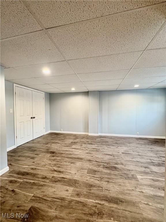 basement featuring hardwood / wood-style floors and a paneled ceiling