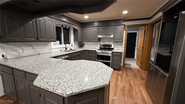 kitchen featuring sink, appliances with stainless steel finishes, gray cabinetry, light stone counters, and tasteful backsplash