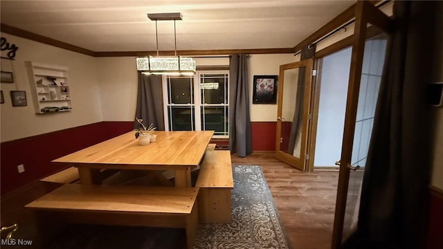 dining room with hardwood / wood-style flooring, crown molding, and french doors