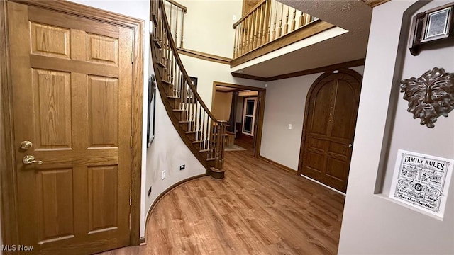 foyer entrance with wood-type flooring and ornamental molding