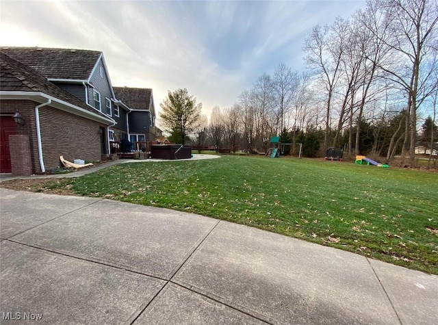 view of yard featuring a hot tub and a playground