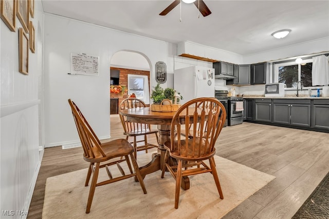 dining room featuring ceiling fan, sink, and light hardwood / wood-style floors