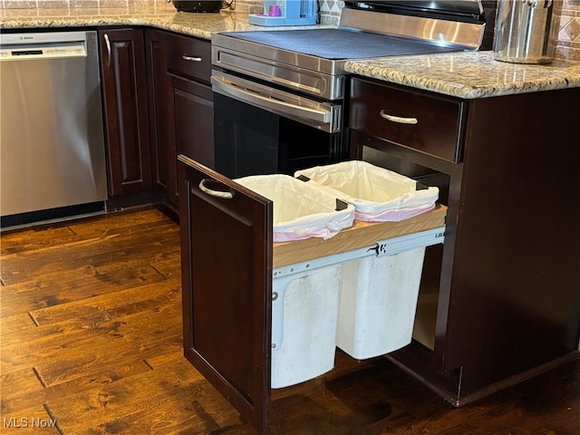 kitchen featuring dark brown cabinetry, dark wood-type flooring, and appliances with stainless steel finishes