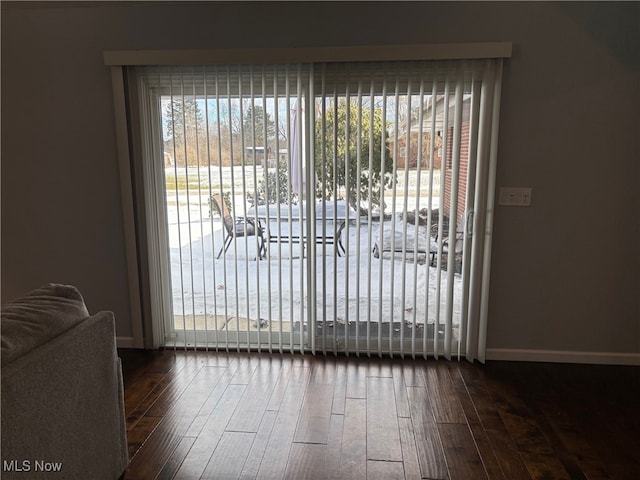 doorway with a healthy amount of sunlight and dark hardwood / wood-style flooring