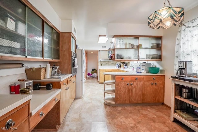 kitchen with tasteful backsplash, sink, pendant lighting, and oven