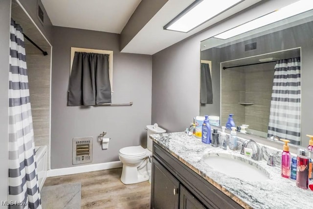 full bathroom with toilet, heating unit, shower / tub combo, vanity, and hardwood / wood-style floors