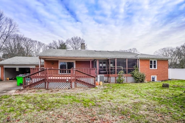 view of front of home featuring a wooden deck, a sunroom, and a front lawn