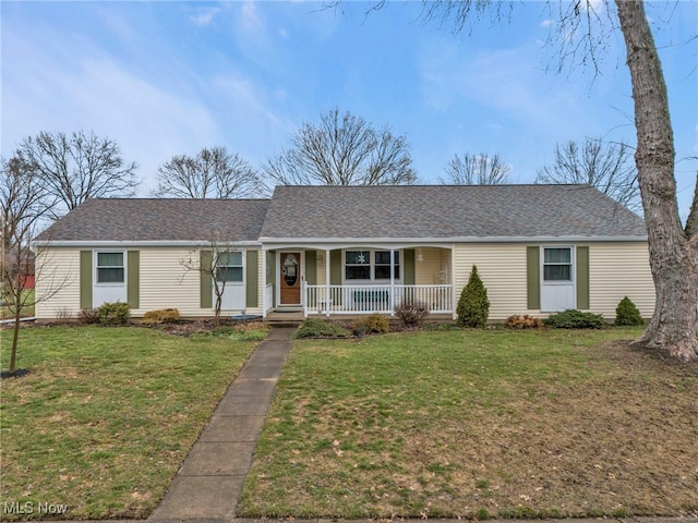 ranch-style house featuring covered porch and a front yard