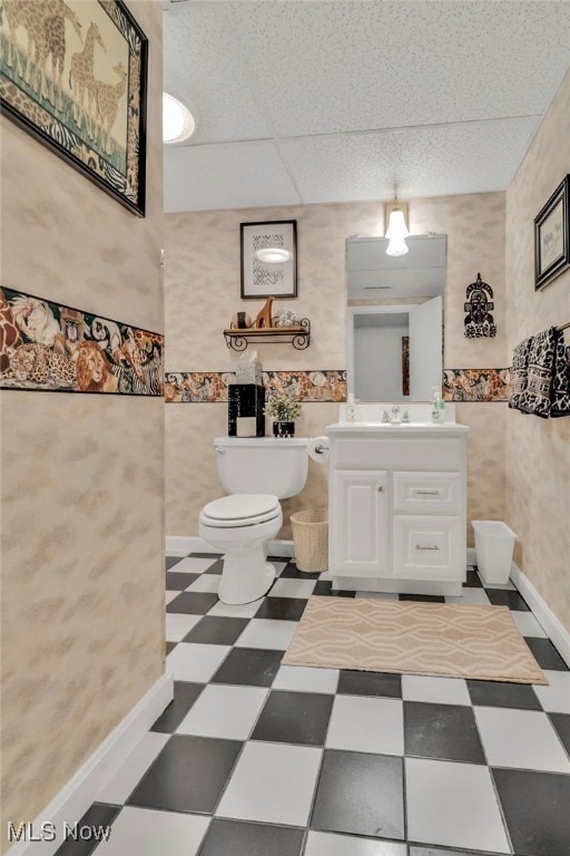 bathroom featuring vanity, a drop ceiling, and toilet