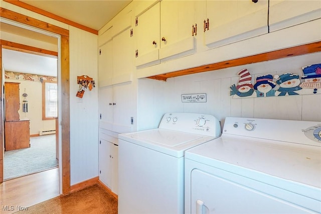 washroom with cabinets, a baseboard radiator, washer and clothes dryer, and light carpet