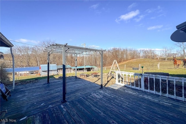 wooden deck featuring a yard and a pergola