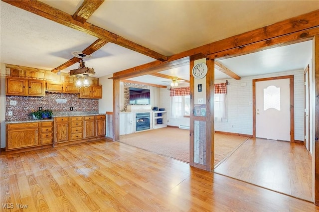 kitchen with ceiling fan, decorative backsplash, beam ceiling, and light hardwood / wood-style flooring