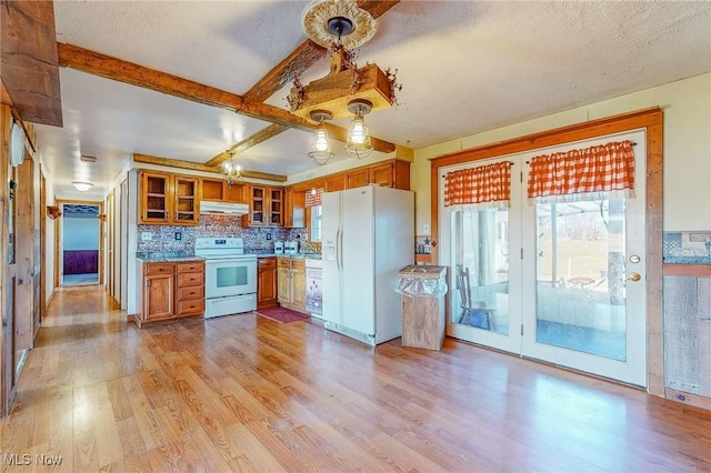 kitchen featuring a textured ceiling, light wood-type flooring, beamed ceiling, white appliances, and decorative backsplash