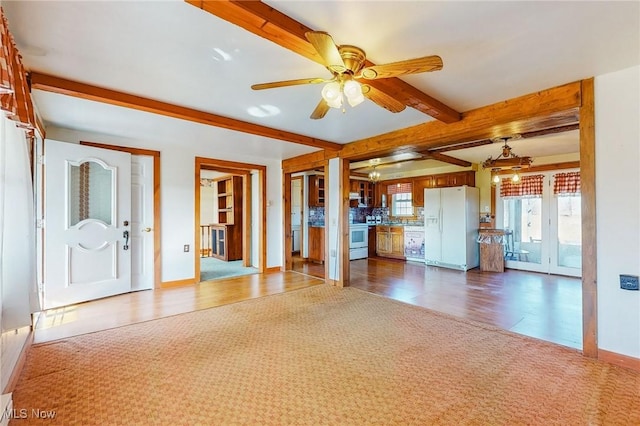 unfurnished living room featuring beamed ceiling, carpet flooring, and ceiling fan