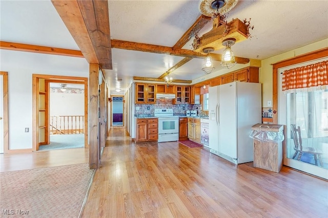 kitchen with white appliances, plenty of natural light, beam ceiling, and light hardwood / wood-style floors