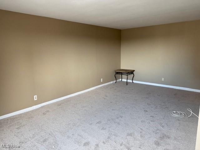 unfurnished room with carpet floors and baseboards