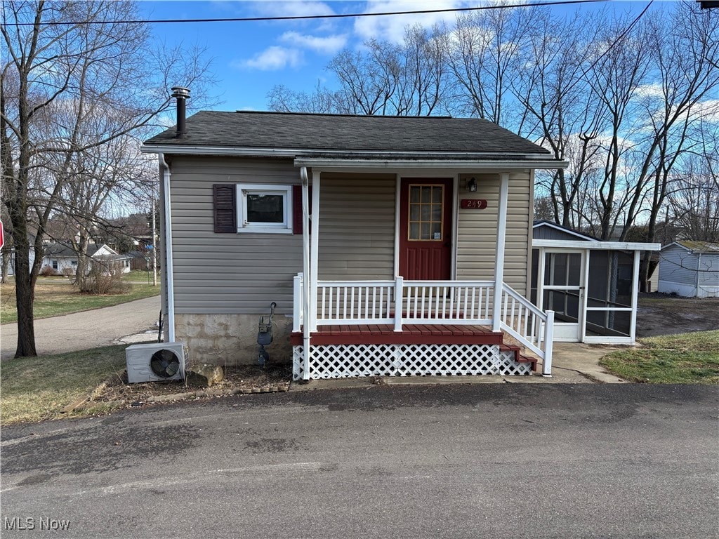 view of front facade with covered porch, a sunroom, and ac unit