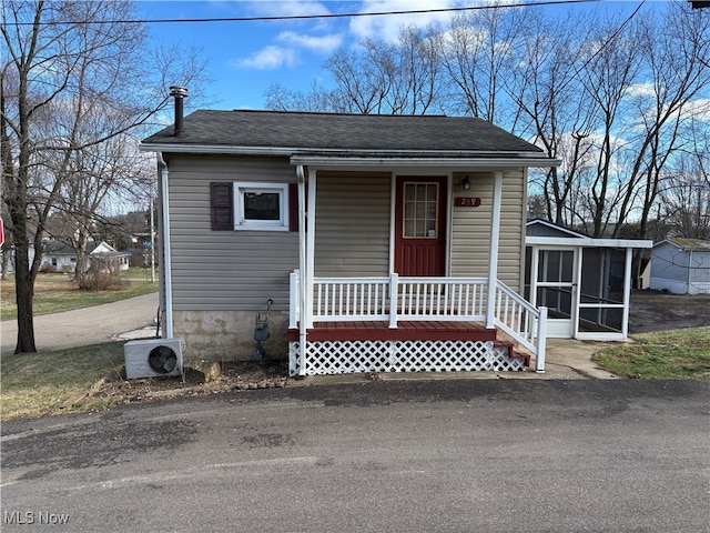 view of front facade with covered porch, a sunroom, and ac unit