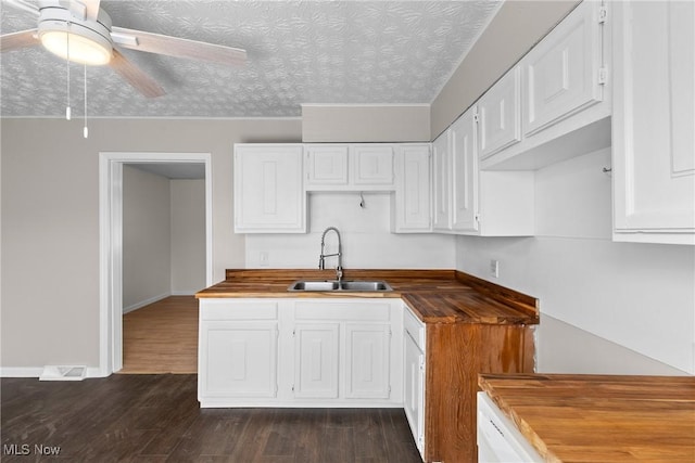 kitchen with sink, ceiling fan, butcher block counters, white cabinetry, and dark hardwood / wood-style floors