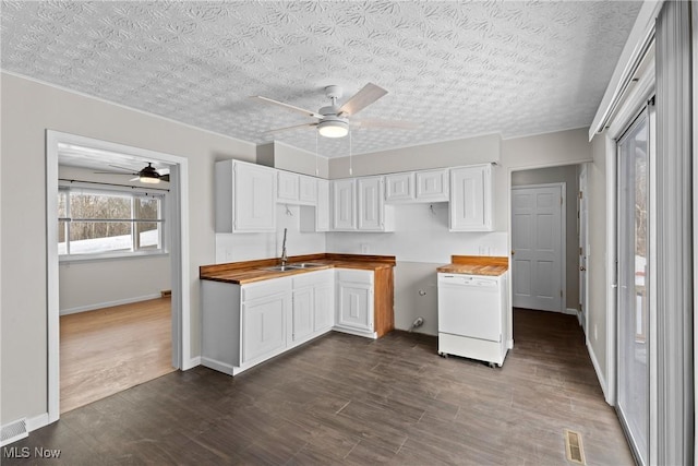 kitchen featuring butcher block counters, sink, dishwasher, and white cabinets