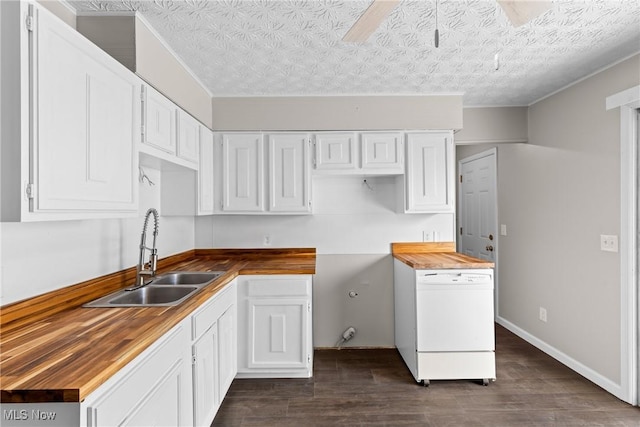 kitchen featuring white dishwasher, sink, white cabinetry, and wooden counters