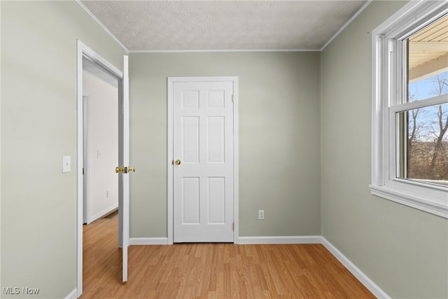 unfurnished bedroom with ornamental molding, a textured ceiling, and light hardwood / wood-style floors