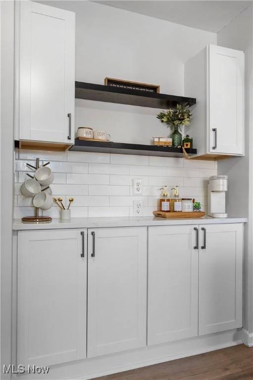 bar featuring white cabinetry, decorative backsplash, and dark hardwood / wood-style flooring