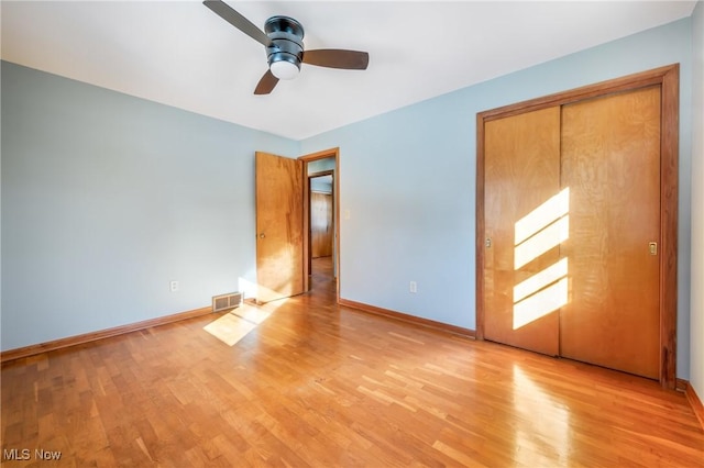 unfurnished bedroom featuring ceiling fan, a closet, and light hardwood / wood-style flooring