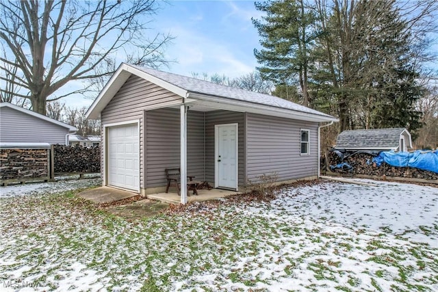 snow covered structure featuring a garage