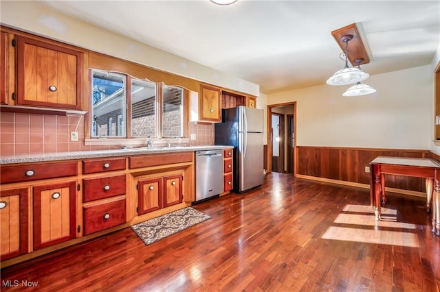 kitchen featuring stainless steel appliances, sink, dark hardwood / wood-style flooring, and decorative light fixtures