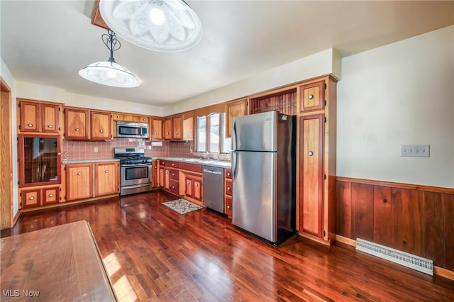 kitchen featuring pendant lighting, sink, backsplash, stainless steel appliances, and dark hardwood / wood-style floors