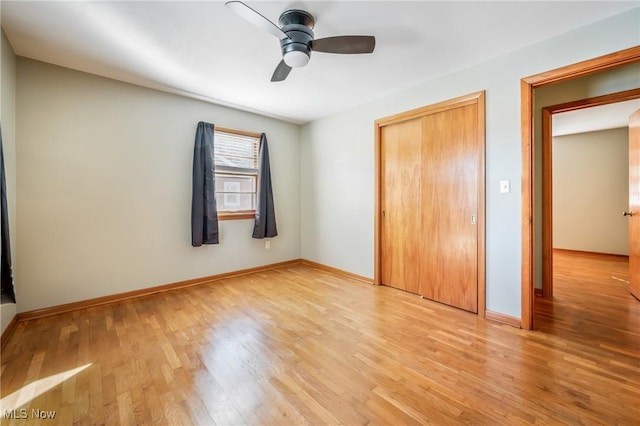 unfurnished bedroom featuring ceiling fan, light wood-type flooring, and a closet